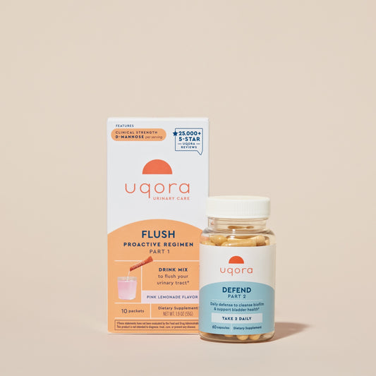 A box of packets that says 'Uqora Pink Lemonade' Flush, and a bottle with pills that says 'Uqora Defend'