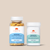 Two Uqora supplement bottles on a beige background - Defend & Promote