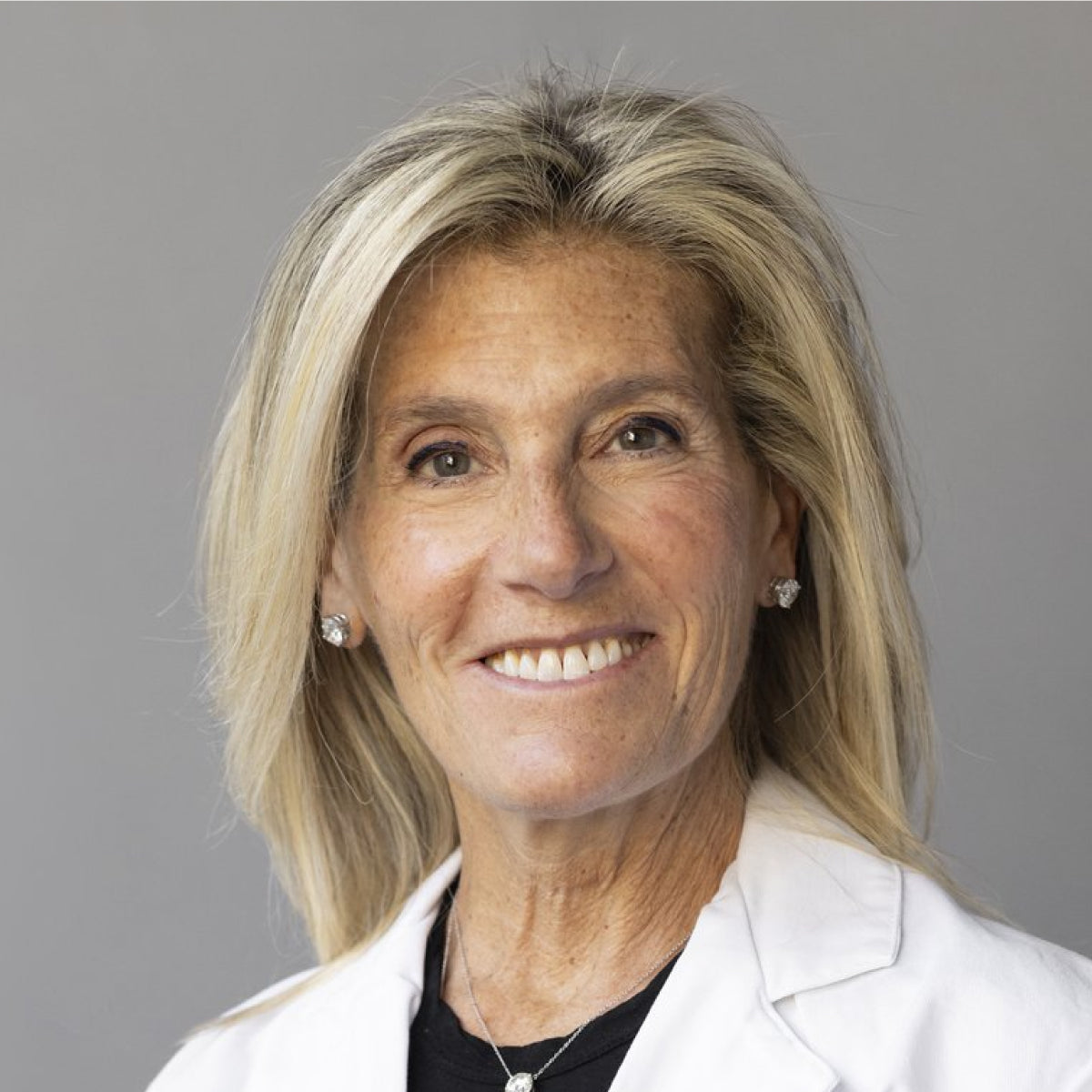 Portrait picture of a lady in a white coat, smiling